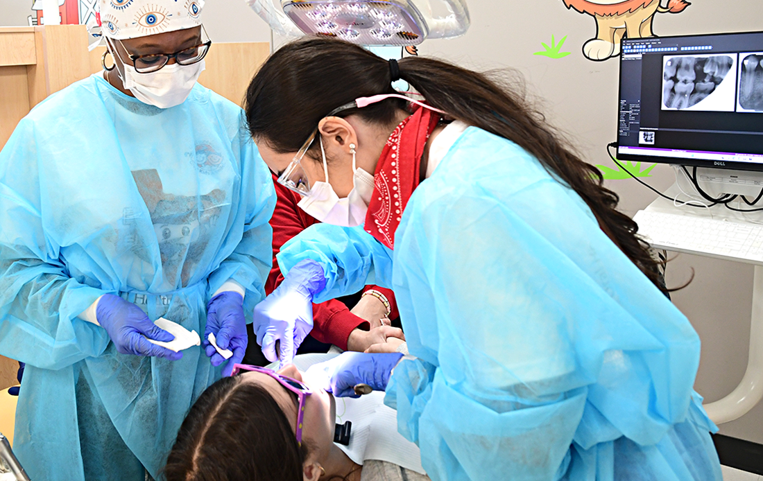 Dentist and assistant working on a young patient