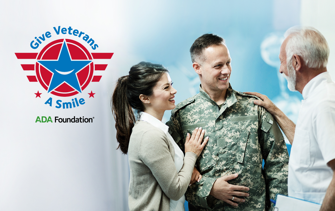 A veteran is standing, smiling with two people